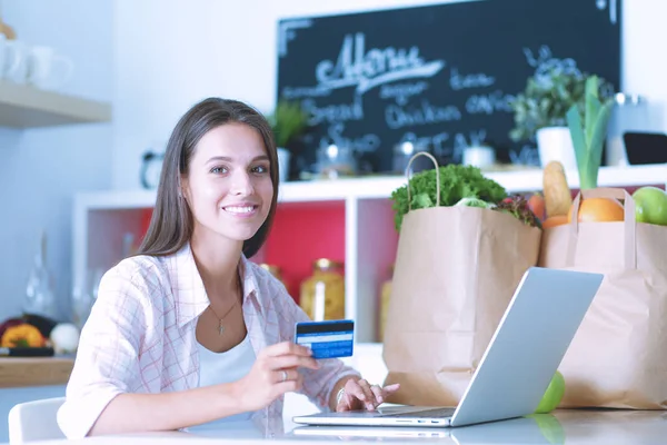 Smiling woman online shopping using tablet and credit card in kitchen . Smiling woman — Stock Photo, Image