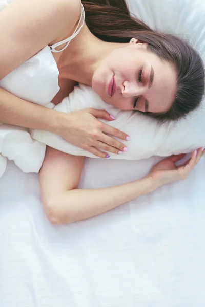 Bella ragazza dorme in camera da letto, sdraiata sul letto . — Foto Stock