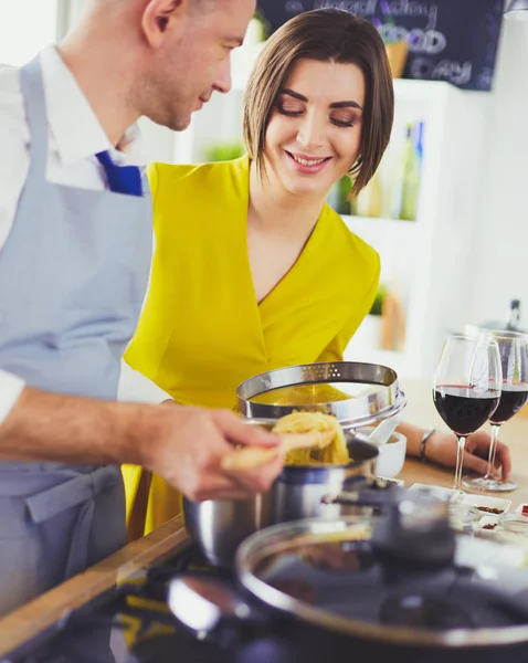 Casal atraente no amor cozinhar e abre o vinho na cozinha, enquanto eles cozinham o jantar para uma noite romântica — Fotografia de Stock