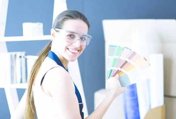 Jonge vrouw met een kleurstaal bij schilderen schilder . — Stockfoto