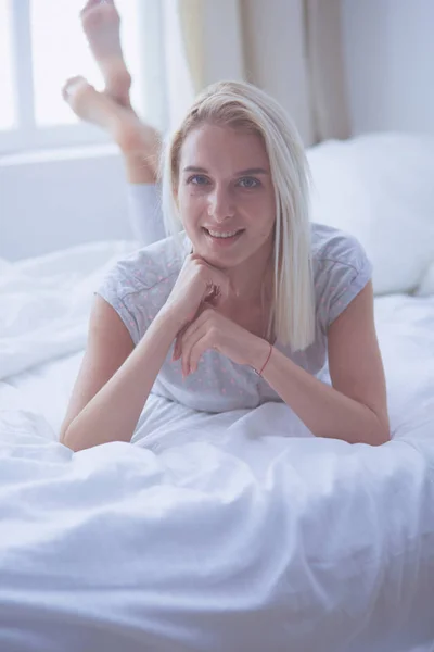 Mujer bonita acostada en su cama en casa — Foto de Stock