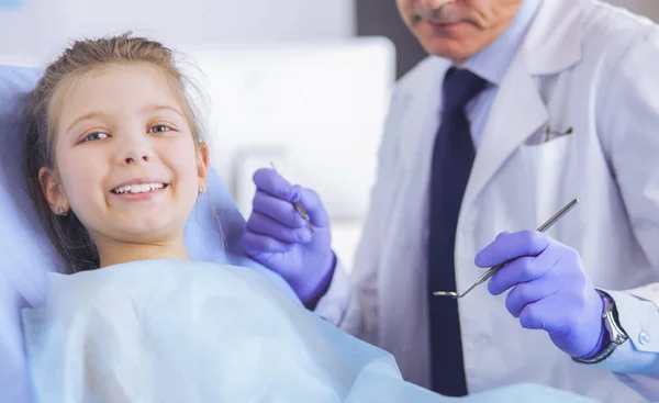 Niña sentada en el consultorio de dentistas —  Fotos de Stock