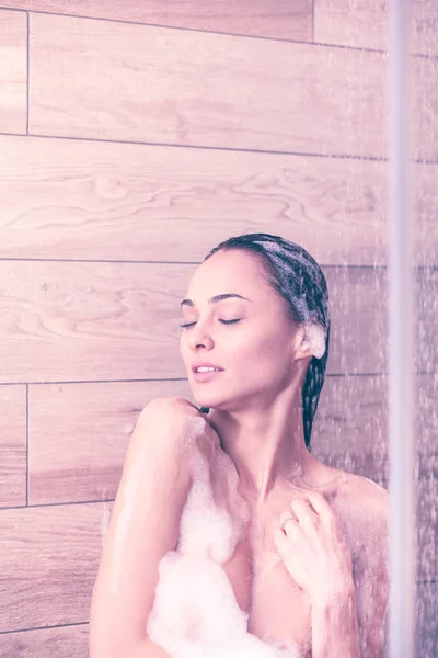 Junge schöne Frau unter der Dusche im Badezimmer. — Stockfoto