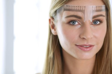 Kaşlar için kalıcı makyaj. Güzellik salonunda kalın kaşlı güzel bir kadın..