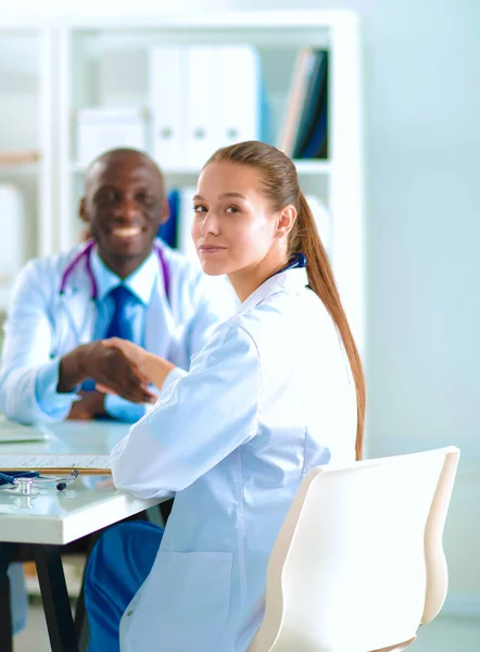 Due giovani medici felici sorridenti che stringono la mano in ufficio. Dottori. Lavoro di squadra — Foto Stock