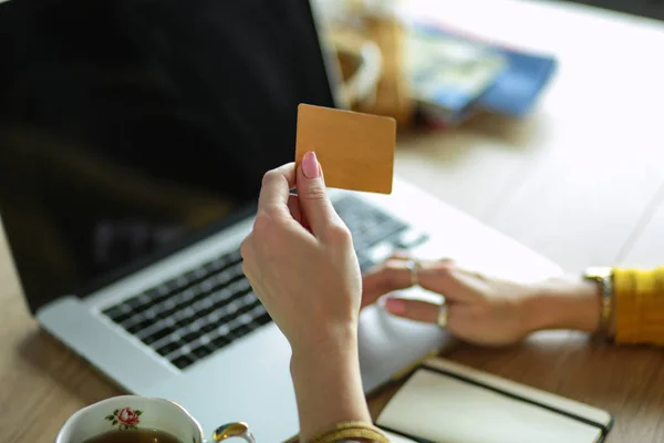 Młoda kobieta trzymająca kartę kredytową i korzystająca z laptopa. Koncepcja zakupów online — Zdjęcie stockowe