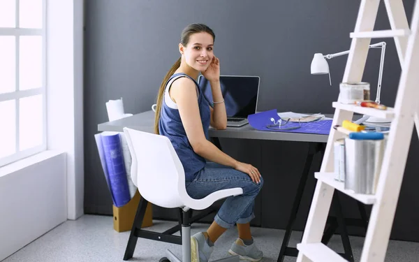 Masasında enstrümanlar, planlar ve dizüstü bilgisayarlarla oturan genç bir kadın.. — Stok fotoğraf