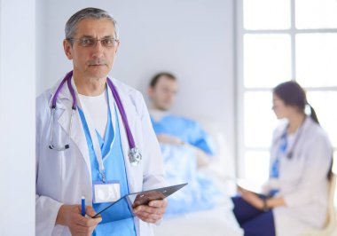 Doktor bir hastanın ve doktorun önünde klasörü tutuyor.