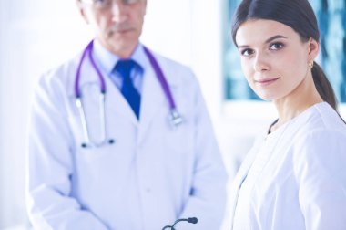 İki doktor hastanedeki konferans odasında, biri kameraya bakıyor.