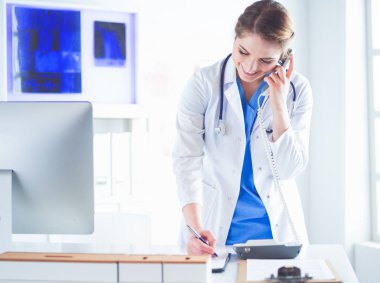 Telefonda konuşan gülümseyen güzel bir hemşirenin portresi.