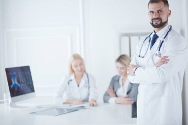 Tıbbi grubun önünde genç bir erkek doktor.