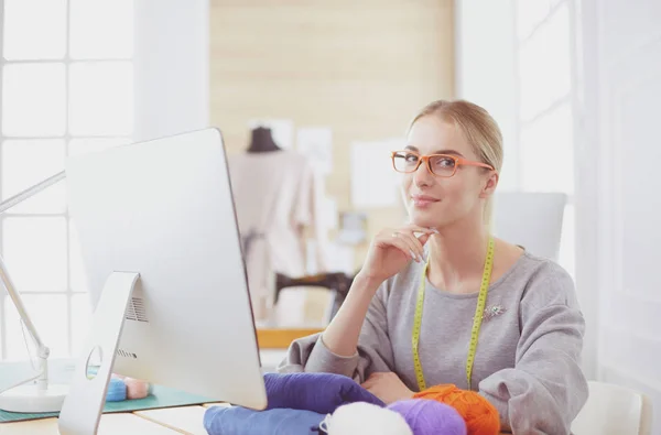 Modedesignerin arbeitet im Atelier und sitzt am Schreibtisch — Stockfoto