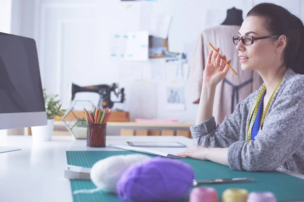 Módní návrháři pracující ve studiu sedící na stole. — Stock fotografie