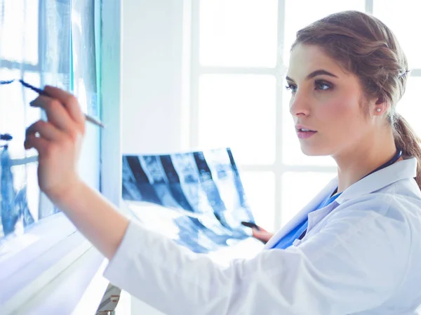 病院で肺のX線写真を見ている若い女性医師 — ストック写真