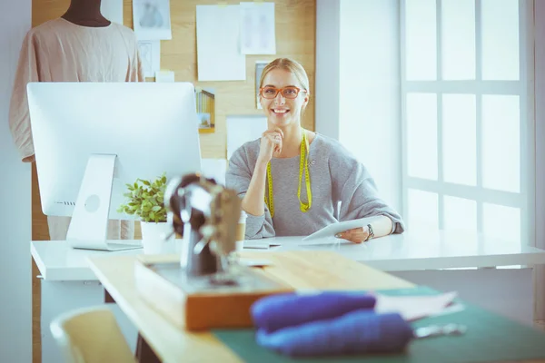 Mooi jong meisje in een fabriek met een naaimachine aan de tafel. — Stockfoto