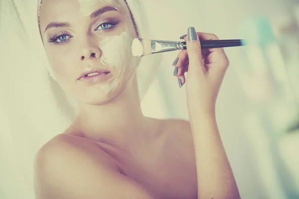 Фотографія молодої жінки, що наносить порошок для обличчя у ванній — стокове фото