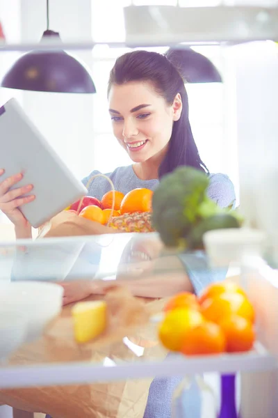 微笑的女人从冰箱里拿出新鲜的水果，健康的食物概念 — 图库照片