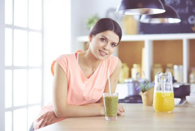 Mutfakta masada oturan genç bir kadın.