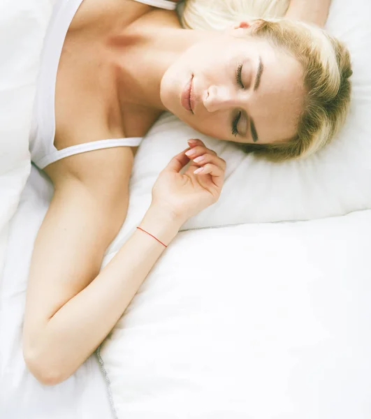 Ładna kobieta leży na łóżku w domu. — Zdjęcie stockowe