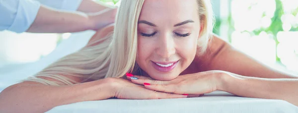 Beautiful young woman lying in spa salon — Stock Photo, Image