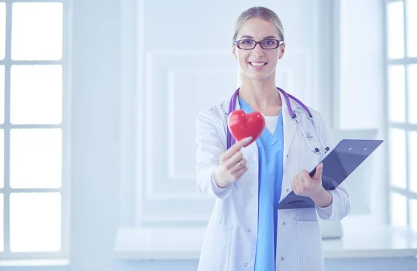 Médica com o estetoscópio segurando o coração — Fotografia de Stock