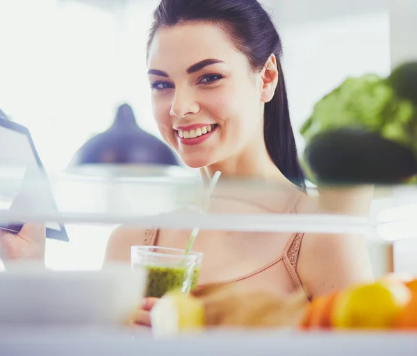 Mujer sonriente sacando una fruta fresca de la nevera, concepto de comida saludable. —  Fotos de Stock