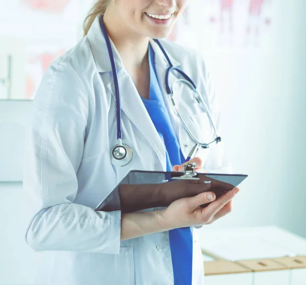 Médico sonriente con una carpeta en uniforme de pie — Foto de Stock