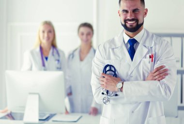 Tıbbi grubun önünde genç bir erkek doktor.