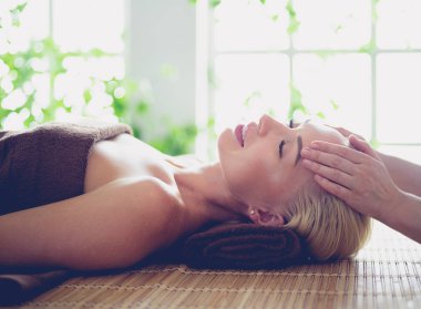 Güzel bir kadın güzellik salonunda yüz masajı yapıyor.