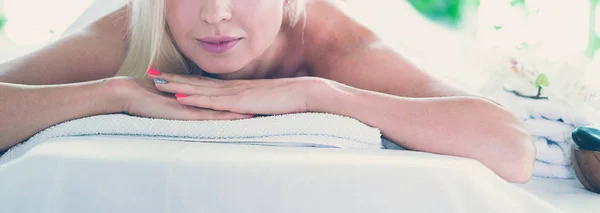 Bella giovane donna sdraiata nel salone spa — Foto Stock