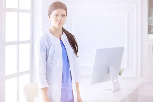 Porträtt av ung kvinna läkare i vit rock stående på sjukhus — Stockfoto