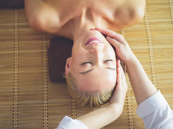 Jovem mulher desfrutando de massagem no salão de spa — Fotografia de Stock