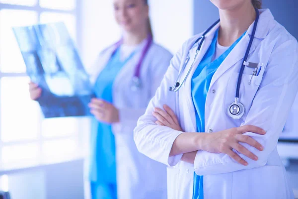 Nahaufnahme von Ärzten mit gekreuzten Händen und Kollegen mit Röntgenbild im Hintergrund. — Stockfoto