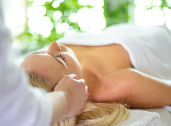 Hermosa mujer haciendo masaje facial en un salón de spa — Foto de Stock