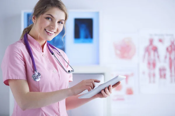 beautiful female healthcare worker using tablet computer in hospital