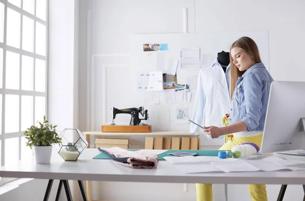 Mujer joven diseñadora de moda trabajando en atelier —  Fotos de Stock