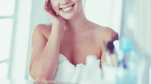 Jonge vrouw in badjas op zoek in badkamer spiegel — Stockfoto