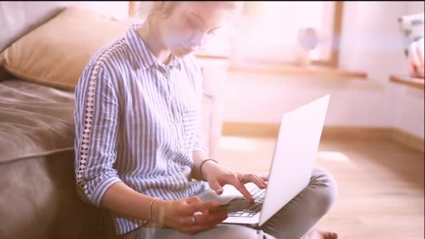 Girll macht Online-Zahlungen. Mädchen hält Bankkarte mit modernem Laptop — Stockvideo