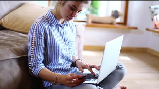 Girll macht Online-Zahlungen. Mädchen hält Bankkarte mit modernem Laptop — Stockvideo