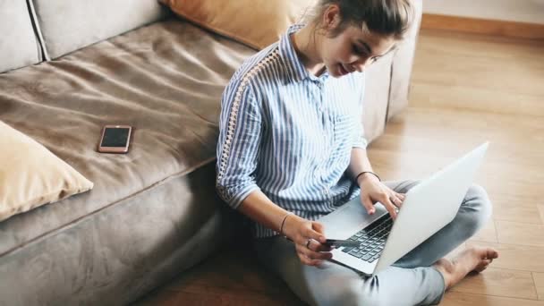 Гирл делает онлайн-платеж. Девушка с банковской картой на современном ноутбуке — стоковое видео
