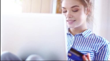 Girll online ödeme yapıyor. Modern dizüstü bilgisayar kullanarak banka kartı tutan kız