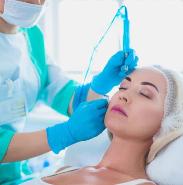 Kaşlar için kalıcı makyaj. Güzellik salonunda kalın kaşlı güzel bir kadın.