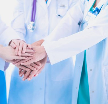 Doktorlar ve hemşireler tıbbi bir ekipte el ele tutuşuyorlar.