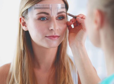 Kaşlar için kalıcı makyaj. Güzellik salonunda kalın kaşlı güzel bir kadın.