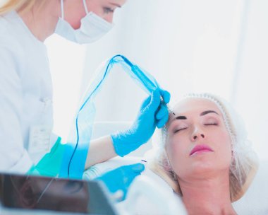 Kaşlar için kalıcı makyaj. Güzellik salonunda kalın kaşlı güzel bir kadın.