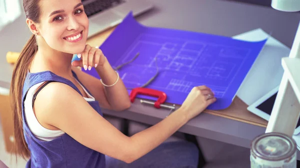 Young woman sitting on the desk in office — Stock Photo, Image