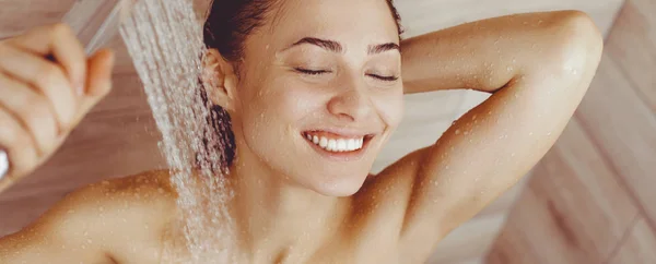 Joven mujer hermosa bajo la ducha en el baño . — Foto de Stock