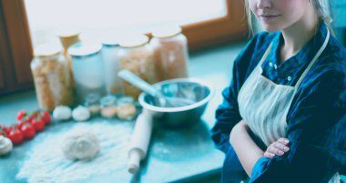 Güzel, genç, gülümseyen bayan doktor masada oturuyor ve yazıyor..