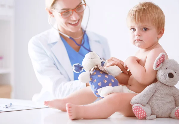 La doctora está escuchando a un niño con un estetoscopio en la clínica — Foto de Stock