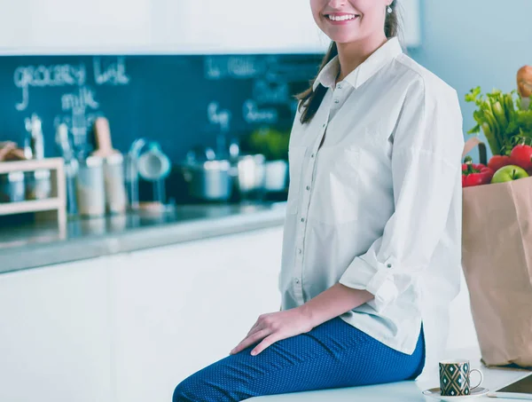 Giderleri planlama ve mutfağını faturalarında ödeme genç kadın.